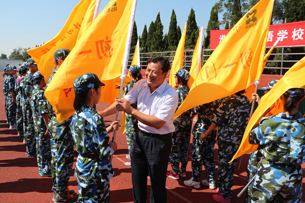 初一年级班主任和班长从朱建文校长、陆怀珍副校长手中接过班旗